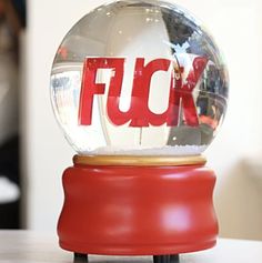 a snow globe sitting on top of a red stand with the word fok in it