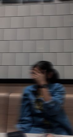 a blurry photo of a person sitting on a bench in front of a building