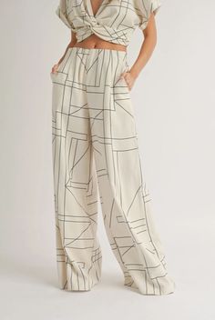 Enoy the good life whether its a long-awaited vacation or brunch with the girls, our Florance Geo Print Wide Leg pants will be a wardrobe staple al season. A classic Neutral featuring a modern geo print graphic, featuring a size zipper and elastic waist band. ( Pairs perfectly with our Matching Geo Print Blouse) Color: Neutral Beige with black geo line Elastic Back Waistband Inseam Measures 29", Measurements taken from size Small Care Instructions: Hand wash Fabric: 92% RAYON 8% SPANDEX Pattern Wide Leg Pants, Cream Pants, Patterned Crop Top, Dressy Shirts, Printed Wide Leg Pants, Grid Pattern, Complete Outfits, Formal Looks, Wide Legs