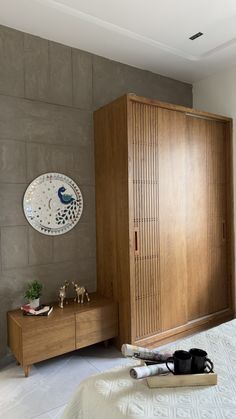 a bed room with a neatly made bed and a large wooden cabinet next to it