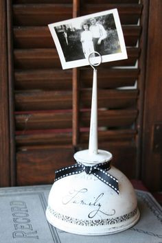 an old fashioned photo holder with a black and white bow on it's head