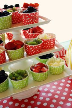 several trays filled with different types of fruit on top of a table covered in polka dots