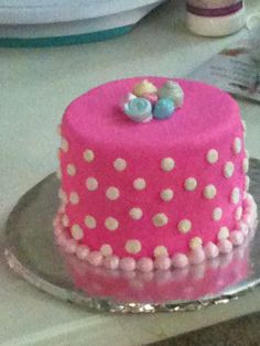 a pink cake with white polka dots on it