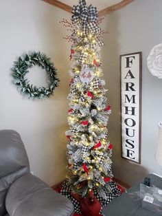 a decorated christmas tree in the corner of a living room next to a gray chair