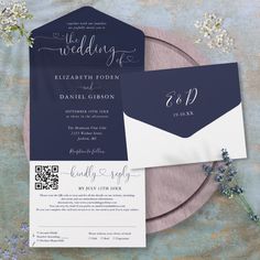 the wedding stationery is displayed on top of a plate with flowers and greenery