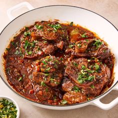 a pot filled with meat and vegetables on top of a table