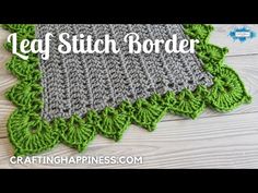 a green and gray crocheted dishcloth sitting on top of a wooden table