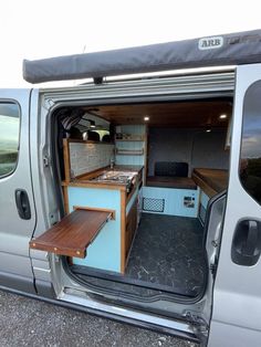 the interior of a van with its door open and wooden table in the back area