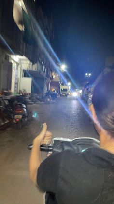 a person riding a motorcycle down a street at night