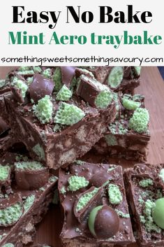 there are many pieces of chocolate and green candy on the cutting board, with one slice cut out