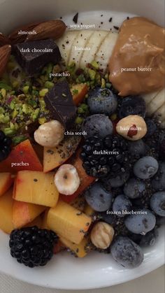 a white bowl filled with different types of fruit and nuts on top of each other