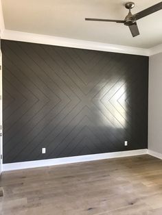 an empty room with wood floors and a ceiling fan