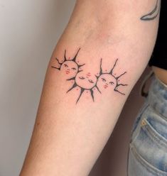 a woman's arm with two sun tattoos on it