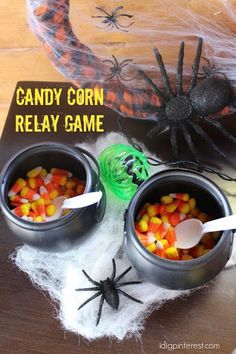 two halloween candy bowls with candy corn in them and a spider on the table next to it