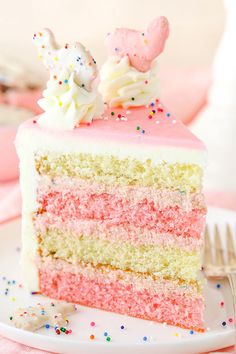 a slice of cake with pink frosting and sprinkles