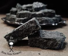 some black rocks on a table with a skull and crossbone logo in the middle