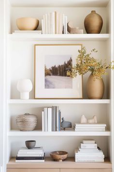 the shelves are filled with books and vases