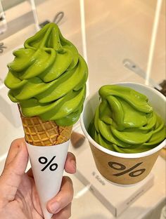 two ice cream cones with green toppings in paper cups