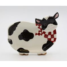 a black and white cow figurine with a scarf on it's neck