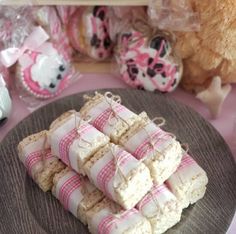 there are many cookies on the plate with pink and white decorations around them, along with a teddy bear