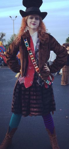 a woman dressed in costume poses for the camera with her hands on her hips while wearing a top hat and boots