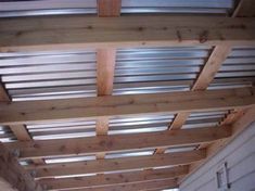 an unfinished wooden ceiling with metal slats