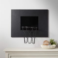 a basketball hoop mounted to the side of a wall above a white table with a vase on it