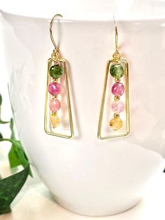 So pretty and cheerful, these earrings will bring you and those who look at you wearing them a smile to your faces! Clear and bright Tourmaline gemstones are in colors of pale yellow, pale pink, pink and grassy green. Each gem has a smooth, high polish. The gemstones dangle within a Vermeil gold frame and hang 1.75 inches on Vermeil gold ear wires. A wonderful gift for any occasion and arrives in a standard gift box. FOR GIFT GIVING: ** Satin gift pouch with a note card and upgraded box is also Multicolor Birthstone Earrings For Gift, Green Tourmaline Earrings For Gift, Handmade Tourmaline Dangle Earrings, Tourmaline Drop Earrings, Box For Gift, Tourmaline Earrings, Earrings Colorful, Tourmaline Jewelry, Colorful Jewelry