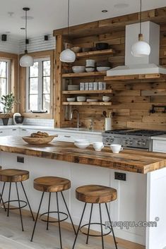 a kitchen with white cabinets and wooden shelves on the wall, along with four stools