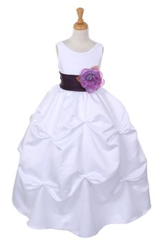 a white flower girl dress on a mannequin stand with a pink sash around the waist