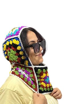 a woman wearing sunglasses and a colorful crochet scarf on top of her head