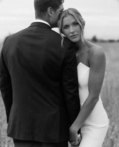 a bride and groom standing in the middle of a field