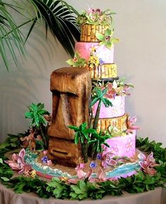 a multi layer cake sitting on top of a table next to a potted plant