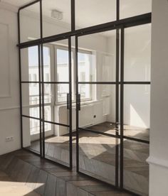 an empty room with glass doors and wood flooring