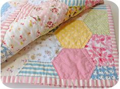 a quilted bed with pink, yellow and blue hexagons on it