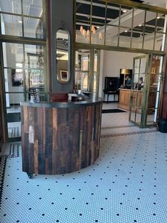 the inside of a restaurant with an open door and large wooden barrel on the floor