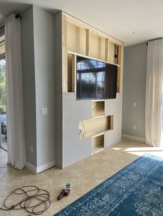 a living room that is being remodeled with the tv in it's center wall