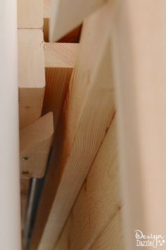 the corner of a wooden structure with nails sticking out of it