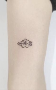 a small flower tattoo on the right side of the leg, with an arrow in the middle