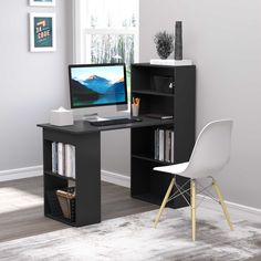 a desk with a computer on it in front of a window and a chair next to it