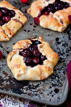 cherry pastries on a baking sheet with cherries around them