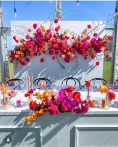 the table is set up with flowers and candles for an outdoor wedding or party reception