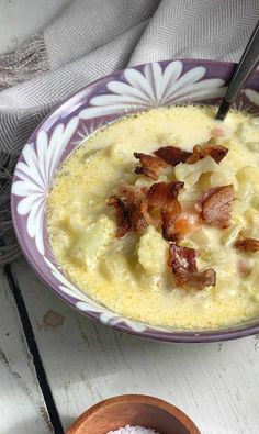 a bowl of soup with bacon in it next to a small bowl of white rice