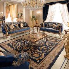 a fancy living room with blue couches and chandelier