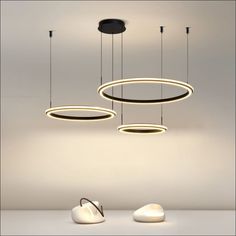 three circular lights hanging from the ceiling in a room with white walls and flooring