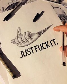 a person holding a pen and drawing something on paper with the words just f k it