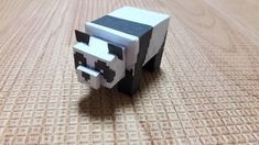 an animal made out of paper sitting on top of a wooden table