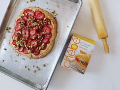 an uncooked pizza sitting on top of a pan next to a rolling pin