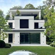 a car parked in front of a white house with black windows and balconies