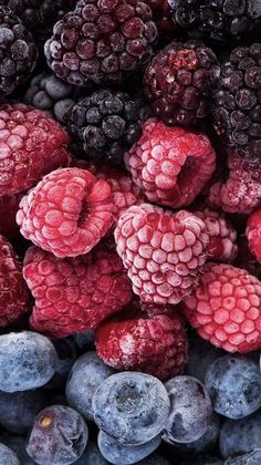 blueberries and raspberries are piled up together